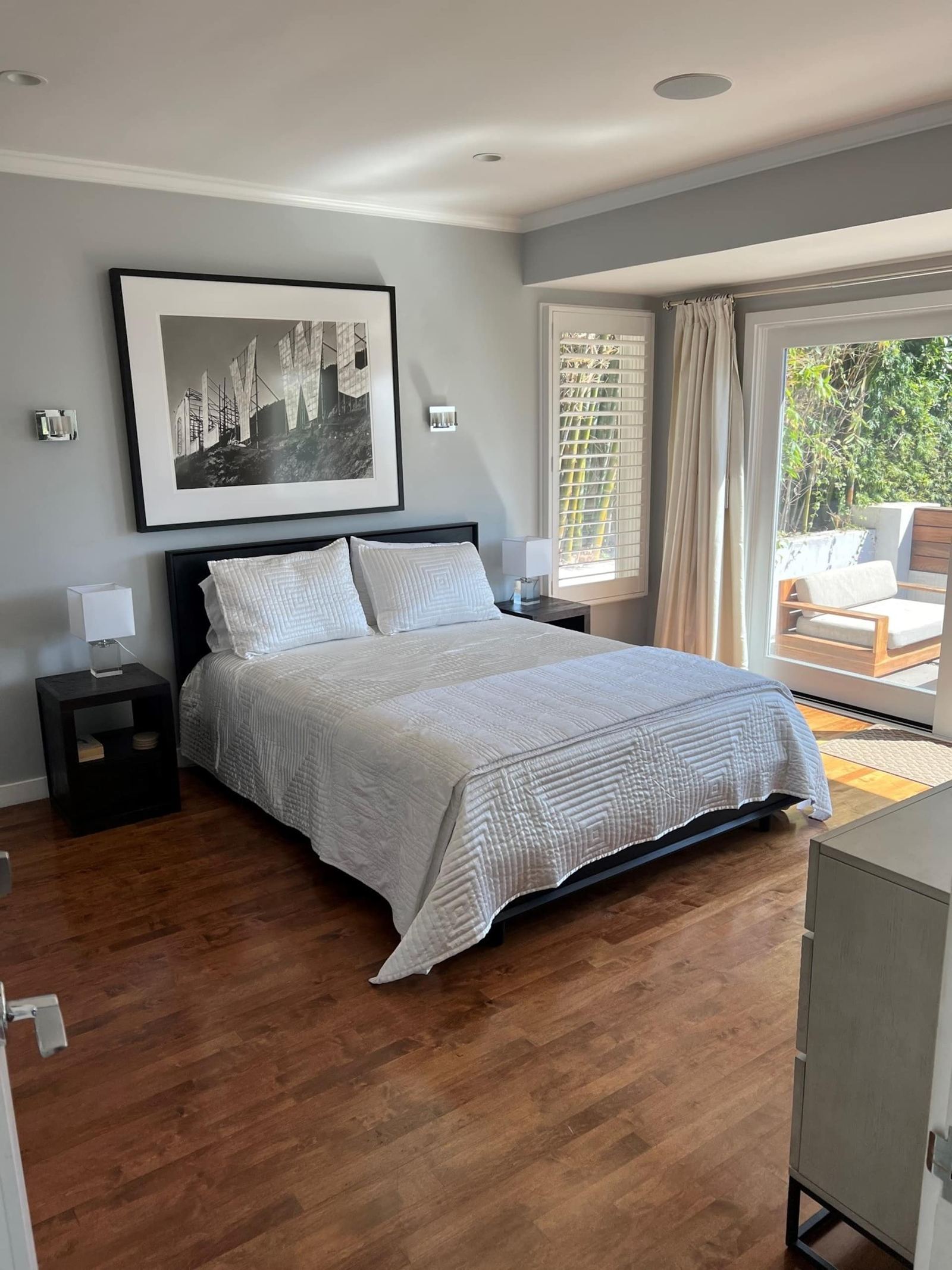 Bedroom with black and white photography and balcony access